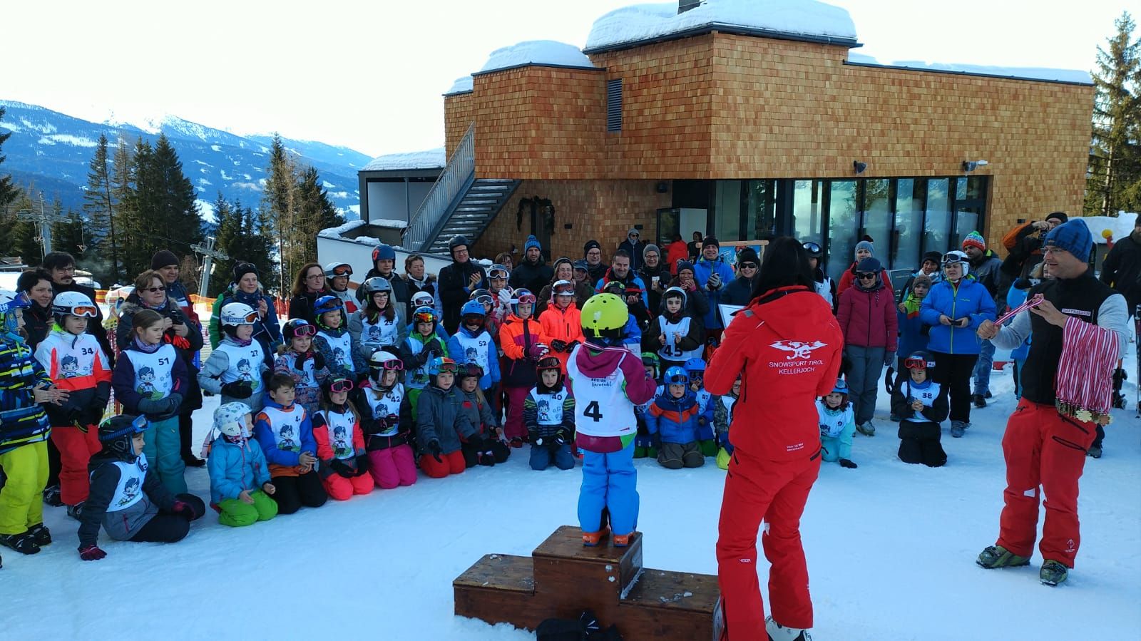 Siegerehrung im Schnee: Kinder auf dem Podest, daneben Schilehrer der Schischule Kellerjoch